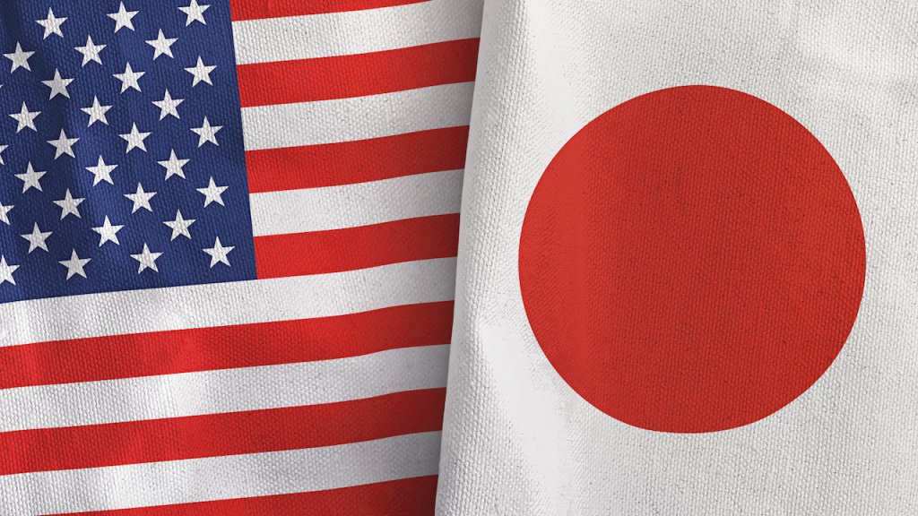 Close-up of the United States flag on the left and the Japan flag on the right, both made of fabric, shown side by side.