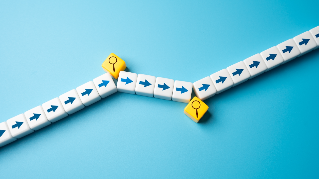 White blocks with blue arrows form a path that splits into two directions, each with a yellow block featuring a magnifying glass icon at the junction, on a blue background.