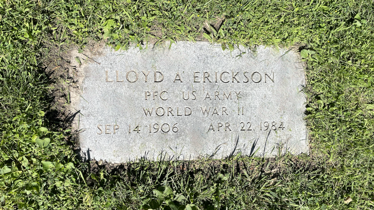 A flat gravestone set in grass reads: Lloyd A Erickson, PFC US Army, World War II, Sep 14 1906, Apr 22 1984.