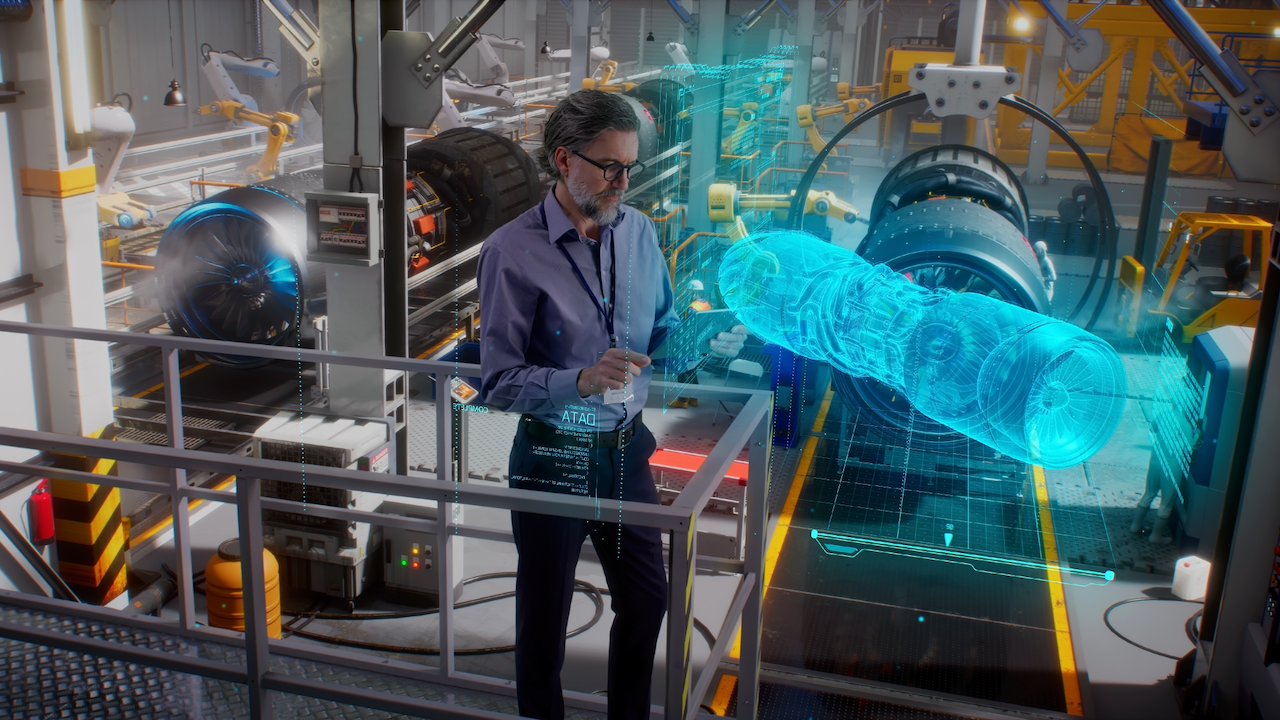 A man in a modern industrial facility interacts with a large, blue, transparent hologram of a turbine engine, surrounded by advanced machinery and robotic arms.