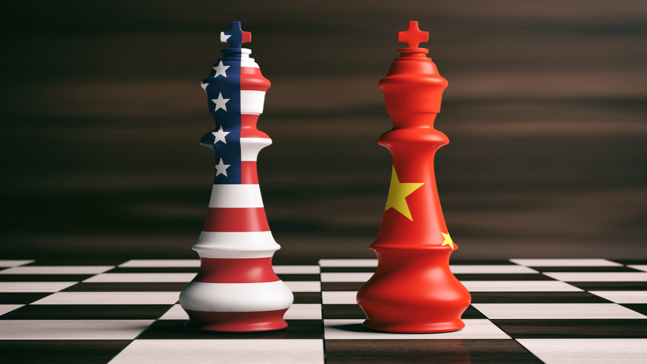 Two chess kings stand on a chessboard. One is decorated with the American flag, the other with the Chinese flag, symbolizing the rivalry or competition between the United States and China.