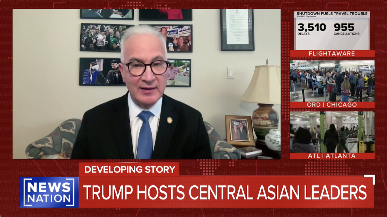 A man in a suit speaks on a news broadcast. The screen shows Trump Hosts Central Asian Leaders and travel trouble stats with images of crowded airports. The segment is branded with NewsNation and Developing Story.